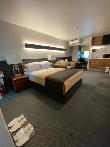 a bedroom with a large bed and a living room at Hotel 草石庵 in Osaka