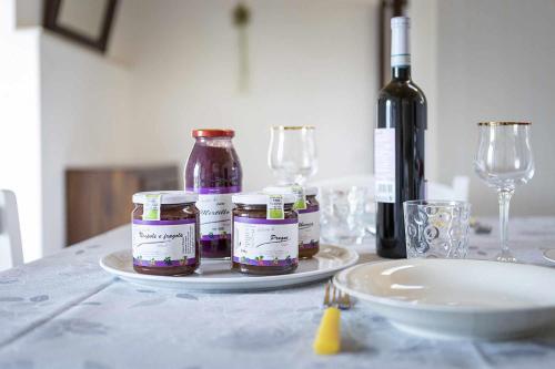a table with jars of jam and a bottle of wine at Agritur Horizon in Carzano