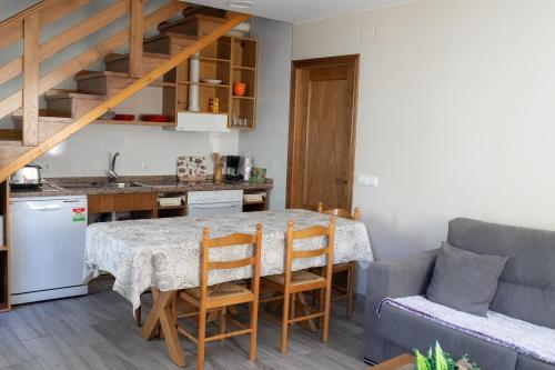 a kitchen and living room with a table and a couch at Casa Rural Las Mestas in Cangas del Narcea