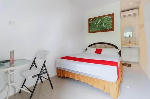 a bedroom with a bed and a table and a desk at RedDoorz near RS Mitra Keluarga Depok in Setasiun Depok
