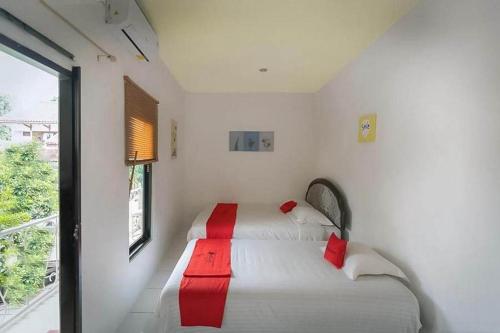 um quarto com duas camas com guardanapos vermelhos em RedDoorz near RS Mitra Keluarga Depok em Setasiun Depok