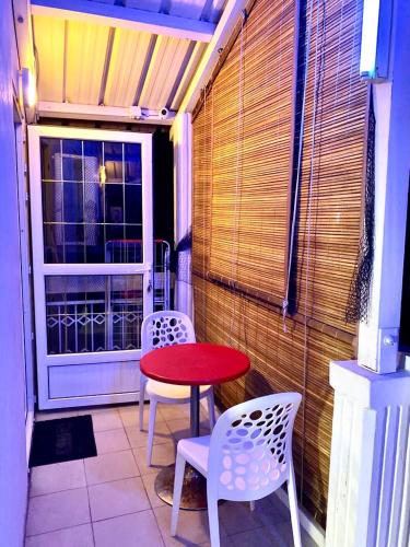 a patio with a table and two chairs and a window at Cosy Flat Beachfront in Flic-en-Flac
