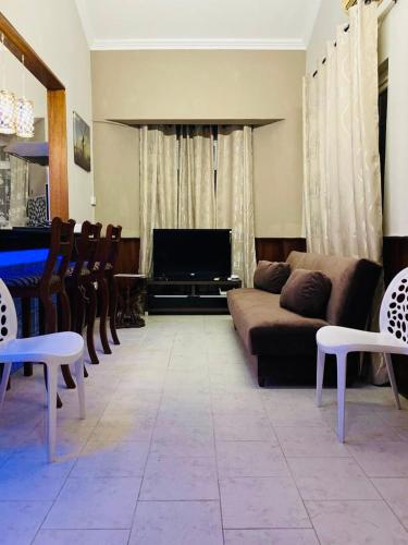 a living room with a couch and a television at Cosy Flat Beachfront in Flic-en-Flac