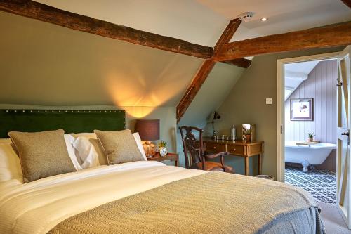 een slaapkamer met een groot bed en een badkamer bij The Horse And Groom Inn in Charlton