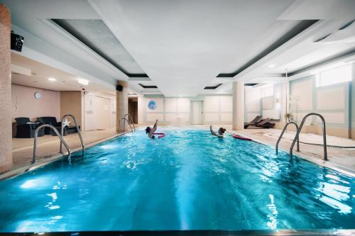 two people playing in a swimming pool at Focus Hotel Premium Elbląg in Elblag