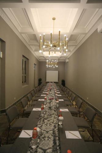 a long table in a room with chairs and a chandelier at Zigna Kampung Batik in Solo