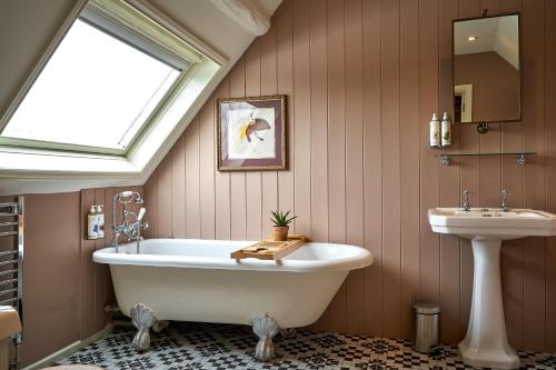 a bathroom with a white tub and a sink at The Horse And Groom Inn in Charlton