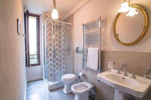 a bathroom with a toilet and a sink and a mirror at Palazzo Veneziano direct at the canal with roof terrace in Venice