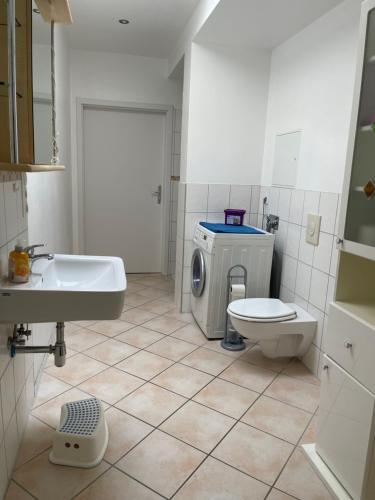 a bathroom with a toilet sink and a washing machine at Familienfreundliches Ferienhaus an der Stadtgrenze zu Berlin in Blankenfelde