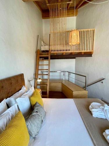 a bedroom with a large bed and a staircase at Casas Do Moinho - Turismo De Aldeia in Odeceixe