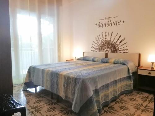 sypialnia z łóżkiem z napisem na ścianie w obiekcie Appartamenti Aurora w Grado
