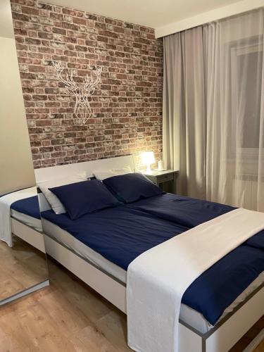 een bed in een slaapkamer met een bakstenen muur bij Apartament Podłęska in Krakau