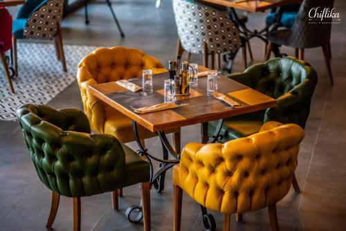 a wooden table and chairs in a restaurant at Chiflika Family Hotel in Asenovgrad