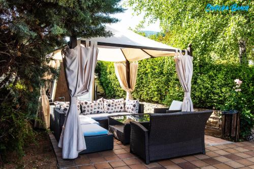 a patio with chairs and a table and an umbrella at Chiflika Family Hotel in Asenovgrad