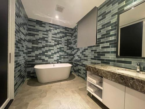 a bathroom with a tub and a sink and a tv at Motel Lin in Taichung