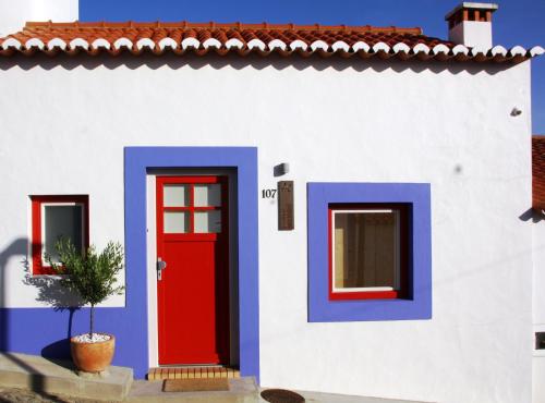 a house with a red and blue door and a plant at Casas Do Moinho - Turismo De Aldeia in Odeceixe