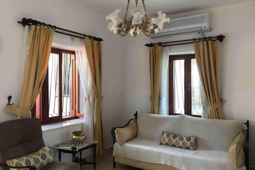 a living room with a couch and a chandelier at A summer house is close to the sea with a garden in Fethiye