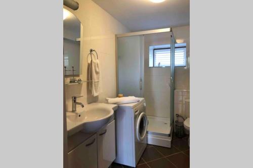 a bathroom with a sink and a washing machine at A summer house is close to the sea with a garden in Fethiye