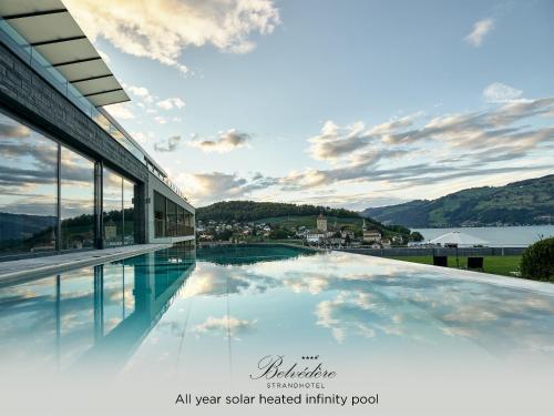 a swimming pool with a view of the mountains at Belvédère Strandhotel in Spiez