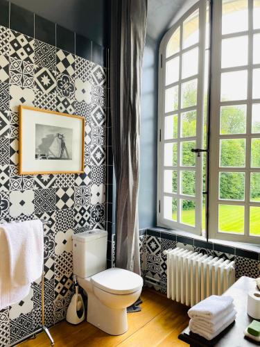 La salle de bains est pourvue de toilettes et de carrelage noir et blanc. dans l'établissement Château de Trébons, à Grainville-Ymauville