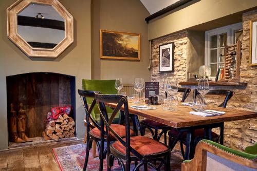 a dining room with a table with wine glasses at The Horse And Groom Inn in Charlton