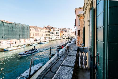 a view of a canal with boats in the water at Palazzo Veneziano direct at the canal with roof terrace in Venice