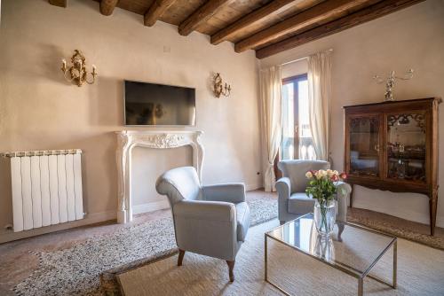 a living room with two chairs and a table at Palazzo Veneziano direct at the canal with roof terrace in Venice