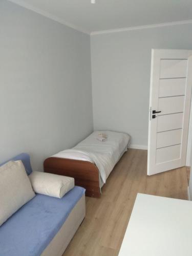 a room with two beds and a couch and a door at Apartament Arkada Centrum in Rzeszów