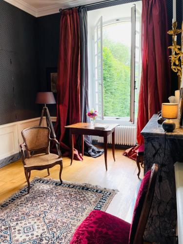 - un salon avec une chaise, une table et une fenêtre dans l'établissement Château de Trébons, à Grainville-Ymauville