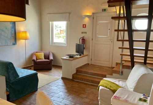 a living room with a couch and a television at Casas Do Moinho - Turismo De Aldeia in Odeceixe