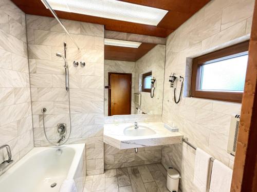 ein Bad mit einer Badewanne, einem Waschbecken und einer Dusche in der Unterkunft Gästehaus Sophienstraße in Stuttgart