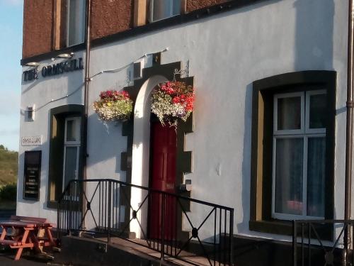 un edificio con una puerta roja con flores. en Ormsgill Inn en Barrow in Furness