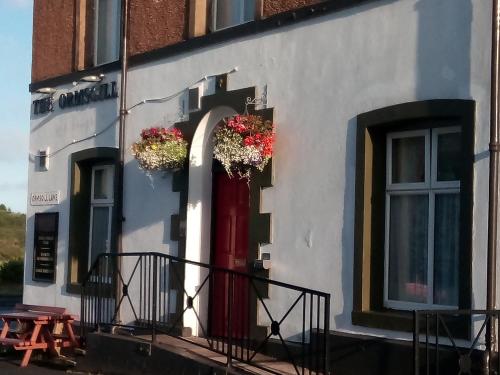 a building with a red door with flowers on it at Ormsgill Inn in Barrow in Furness