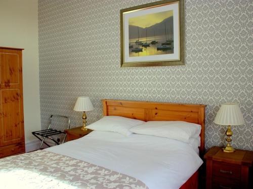 een slaapkamer met een bed met 2 lampen en een foto aan de muur bij Ormsgill Inn in Barrow in Furness