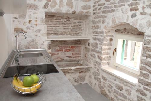 a kitchen with a sink and a bowl of fruit at Old Town Studio in Šibenik