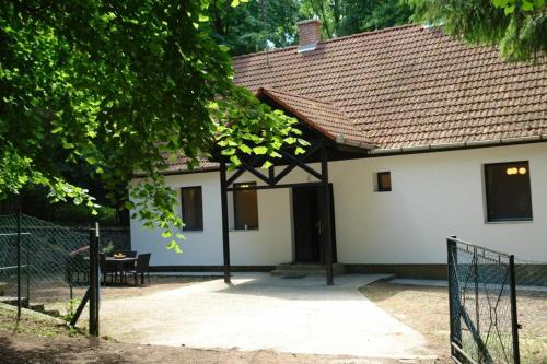 una casa blanca con una puerta delante de ella en Forest gate Vendégház, en Mátraszentimre