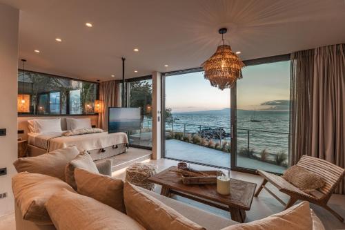 uma sala de estar com um sofá e uma grande janela em Bungalows at Almiros Beach em Kalamata