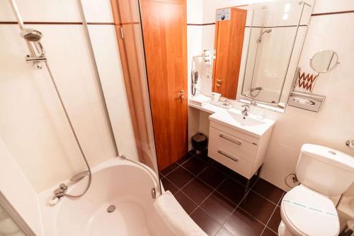 a small bathroom with a toilet and a sink at Best Western Plus Lido Hotel in Timişoara