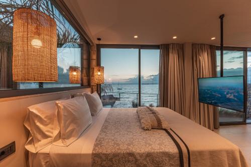um quarto com uma cama grande e uma janela grande em Bungalows at Almiros Beach em Kalamata