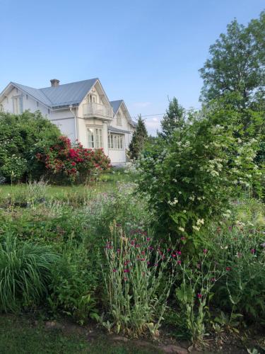 um jardim em frente a uma casa com flores em Susannes B&B em Västerbo