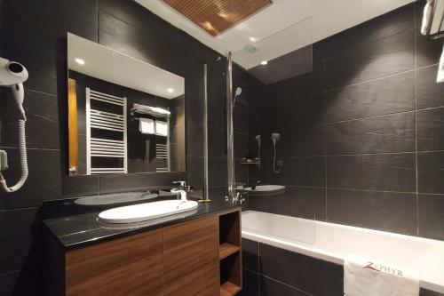Baño negro con lavabo y espejo en ZEPHYR Ifrane en Ifrane