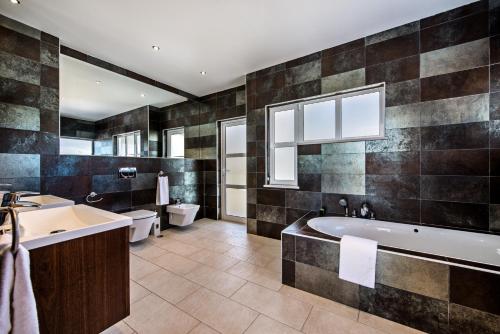 a bathroom with a tub and a toilet and a sink at Vista Mar by Algarve Villa Holidays in Sesmarias