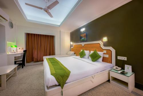 a bedroom with a bed and a desk in a room at Treebo Green View, Park Circus in Kolkata