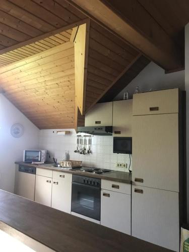 cocina con electrodomésticos blancos y techo de madera en Schangri-la en Ramsau am Dachstein