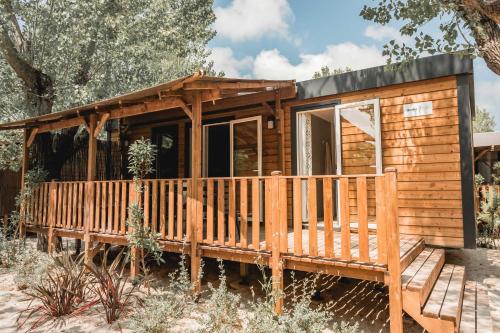 a log cabin with a porch and a deck at Nova Lodges in Grimaud
