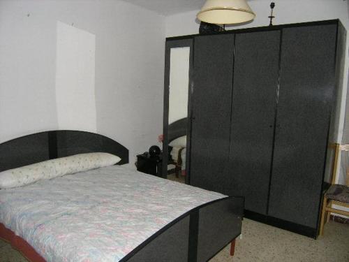 a large black cabinet in a room with a bed at Piso en Sevilla Este in Seville