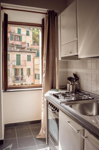 a kitchen with a stove top oven next to a window at Casa Elisa in Riomaggiore