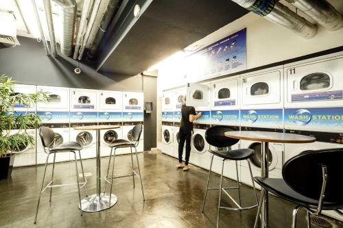 a man standing in a laundry room with washing machines at Chapter Kings Cross in London in London
