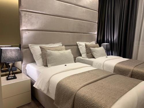 two beds in a hotel room with a headboard at Hotel Leone in Međugorje