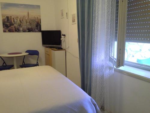 Schlafzimmer mit einem Bett, einem Fenster und einem Tisch in der Unterkunft Isabele in Brodarica